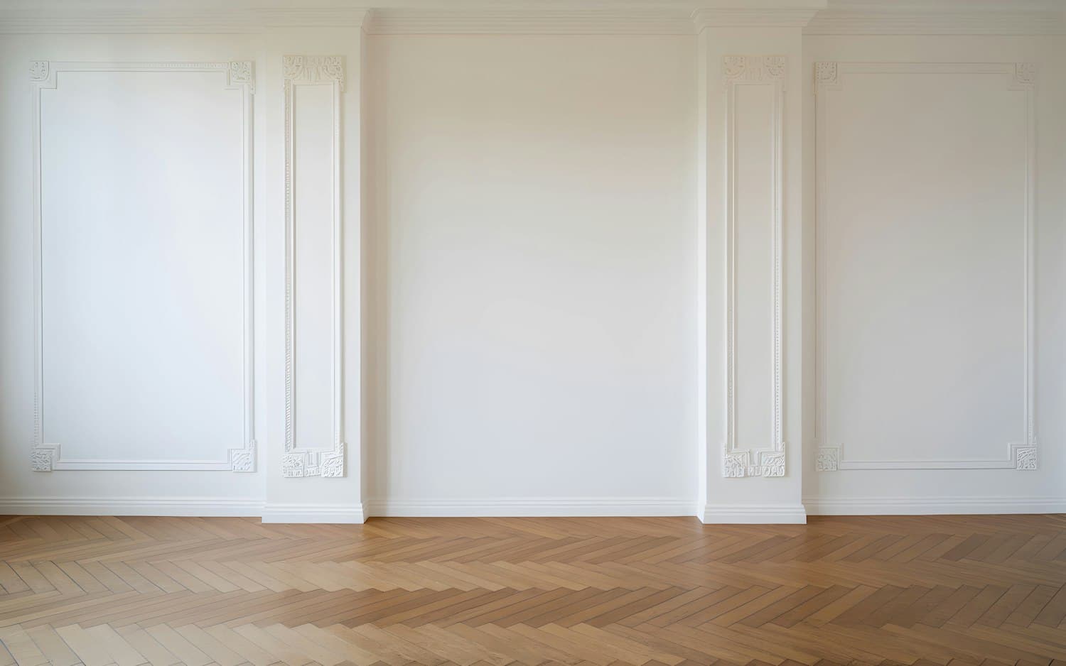 Refurbished period room with panelled walls and herringbone oak flooring